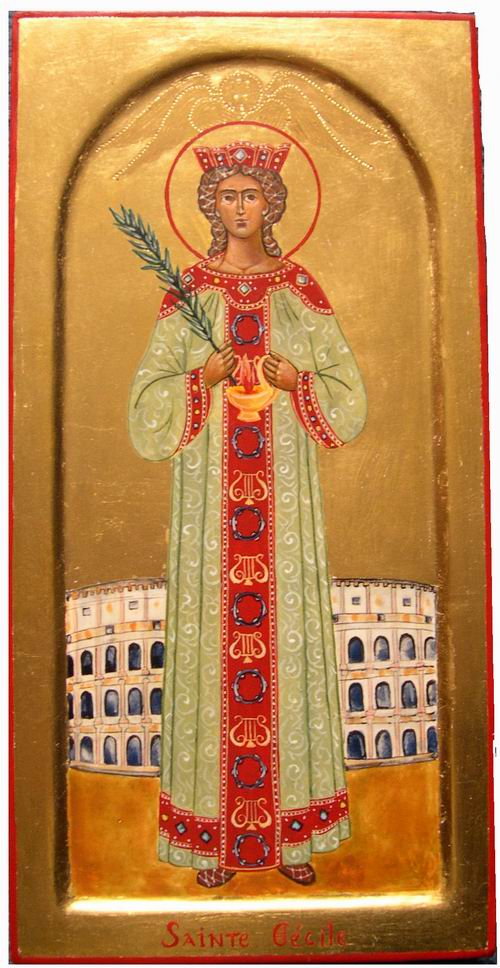 Sainte Cécile est ici représentée dans ses atours de Vierge consacrée ( la lampe fait allusion aux Vierges Sages de l'Evangile qui attendent l'Epoux). Elle porte en main la palme de son martyr et sa robe évoque les robes portées par les femmes martyrs sur les mosaïques paléochrétiennes.